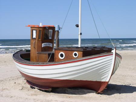 White and Brown Speedboat on White Sand Beside Ocean during Daytime