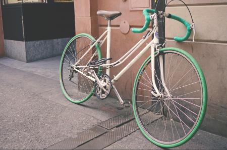 White and Green Bike Leaning on Wall