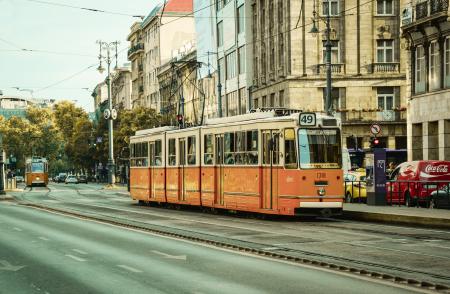 White and Orange Train Near City Buildings