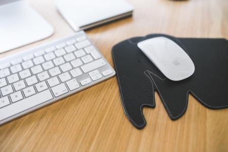 White Apple mouse and keyboard on the black Elephant Pad