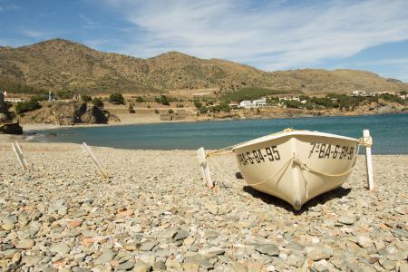 White Boat Placed in the White Stone Area Near Body of Water