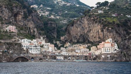 White Buildings Beside Mountain and Body of Water