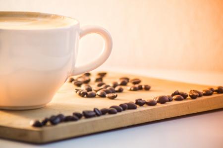 White Ceramic Coffee Mug With Cream Beside Black Coffee Beans
