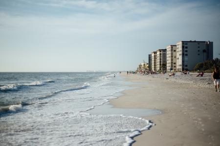 White Cloudy Sky over Seashore With Buildings during Daytime