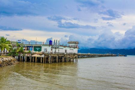 White Concrete Building Beside Body of Water Under Blue and White Sky at Daytime