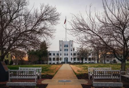 White Concrete Building in Front of Bare Trees