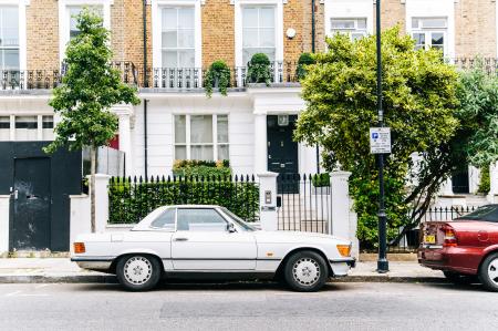White Coupe Near Brown and White Concrete Building