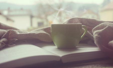 White Hot Mug on Book Near Linen