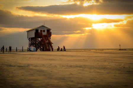 White Lifeguard House on Beach Taken Under White Clouds and Orange Sky