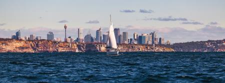 White Sailboat on Body of Water Near City