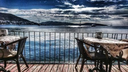 White Table With Two Armchair Set Near Body of Water and Mountain