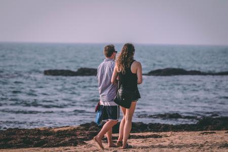 Woman and Man Walking Near Seashore