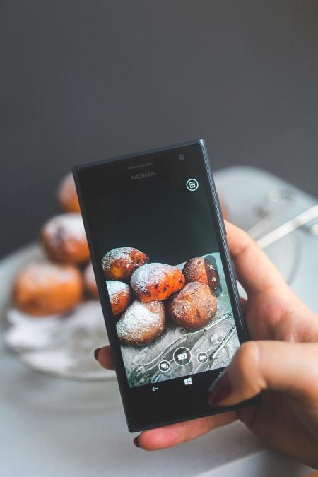 Woman hand taking picture of doughnuts