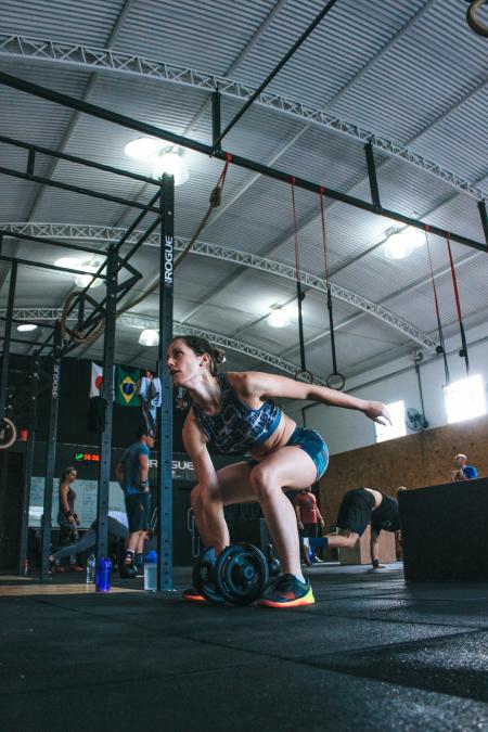 Woman Holding Adjustable Dumbbell With Her Right Hand at Gym