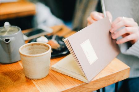 Woman Holding Brown Open Notebook