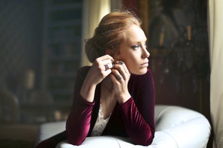 Woman Holding Ears Leaning Elbows on Sofa