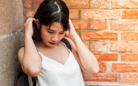 Woman Holding Her Hair While Standing on the Corner