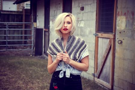 Woman Holding Towel Standing on Front of House