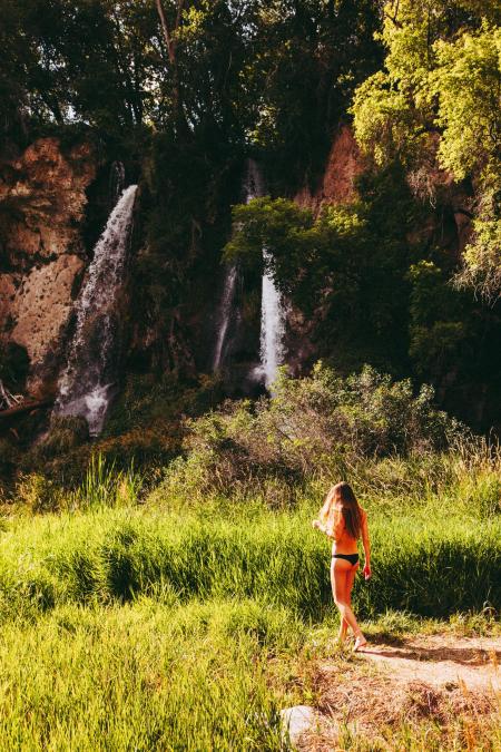 Woman In Black Bikini Bottom Walking Towards Waterfall