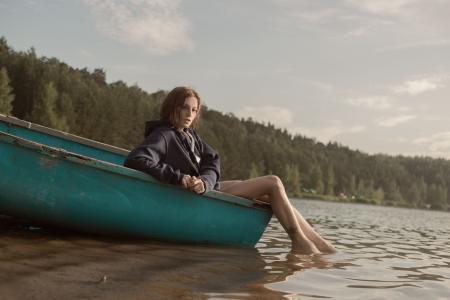 Woman in Black Hoodie Sitting on Blue Kayak