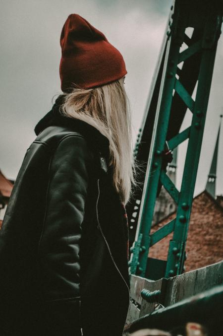 Woman in Black Leather Zip-up Jacket Near Green Metal Stand