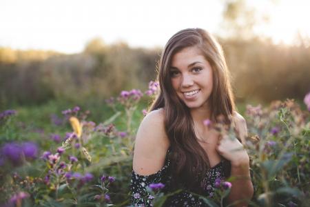 Woman in Black Off Shoulder Dress Standing in Green Flower Field during Daytime