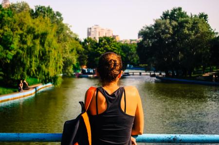 Woman in Black Racerback Top Facing Body of Water and Trees