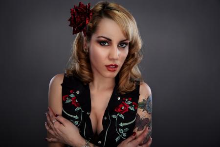 Woman in Black Red and Green Floral Sleeveless Shirt With Red Flower on Her Head and Butterfly Tattoo on Her Left Arm