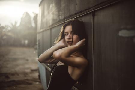 Woman in Black Spaghetti Top Holding Hair Leaning on Vehicle