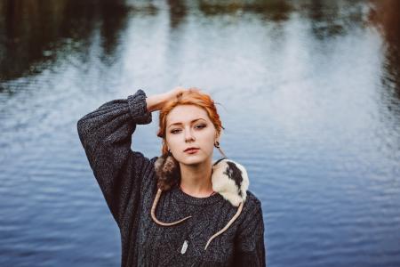 Woman in Black Sweater Standing Near Body of Water during Daytime