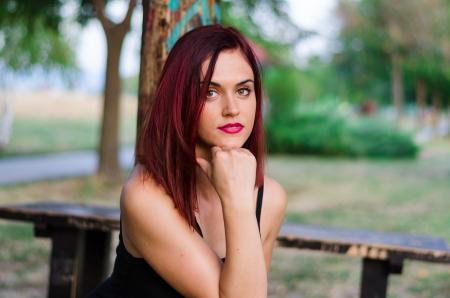 Woman in Black Tank Top Sitting on Bench