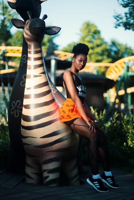 Woman in Black Top Wearing Pair of Black Adidas Shoes