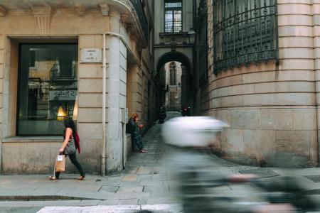 Woman in Black Walking Near Glass Window