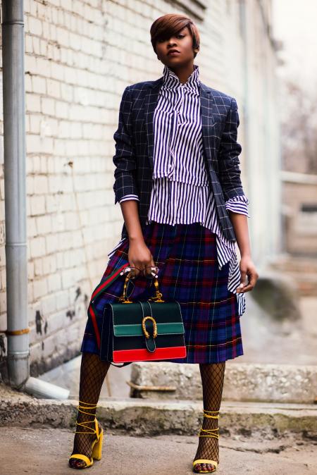 Woman in Blue and White Plaid Cardigan Holding Green and Red Handbag