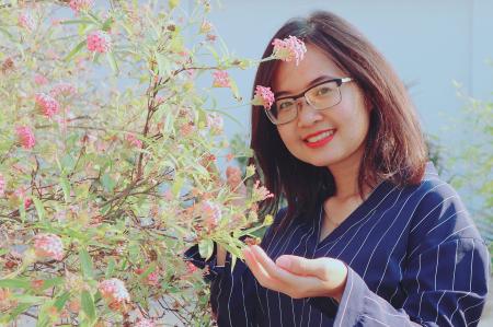 Woman in Blue Striped Top Holding Pink Flowers
