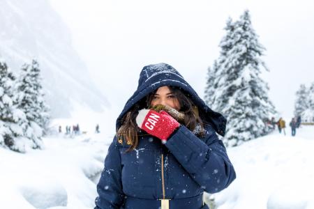 Woman in Blue Zip-up Hooded Jacket Standing on Snow