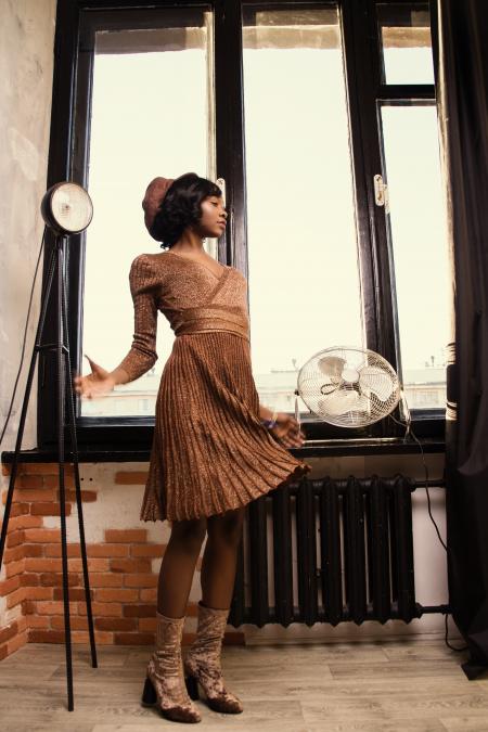 Woman in Brown Dress Standing Beside Black Desk