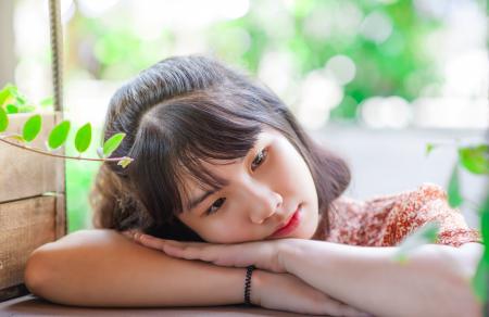 Woman in Brown Top With Hands on Wooden Surface