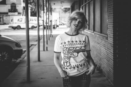 Woman in Crew-neck Shirt Standing Beside Brick Wall Building