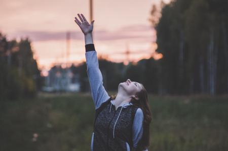 Woman in Gray and Black Zip-up Hoodie Raising Her Right Hand