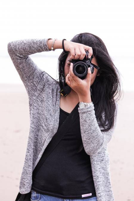 Woman in Gray Cardigan and Black Shirt Holding Black Dslr Camera