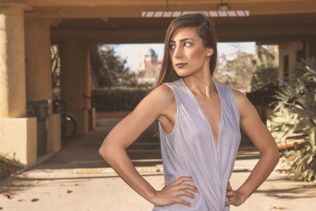 Woman in Gray Sleeveless Top Standing in Front White Bridge