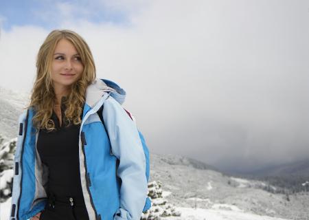 Woman in Green Zip Hooded Jacket on White Mountain With Fogs during Daytime