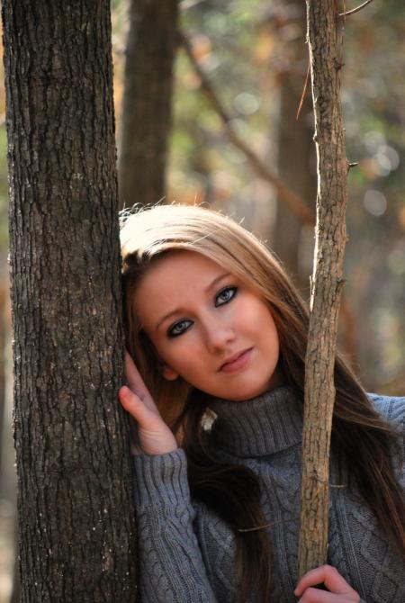 Woman in Grey Sweater Lying on Tree during Daytime