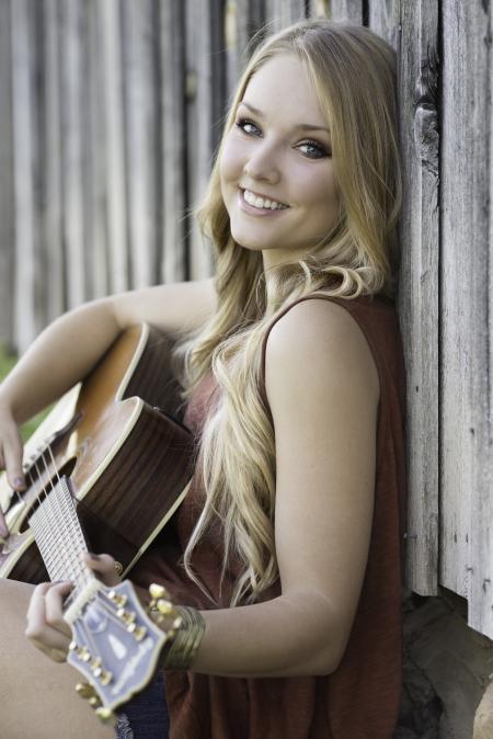 Woman in Maroon Tank Dress Playing Acoustic Guitar Near Wood