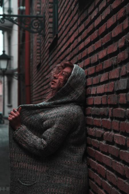 Woman in Orange Sunglasses With Space-dye Cardigan With Hoodie Leaning on Wall Brick