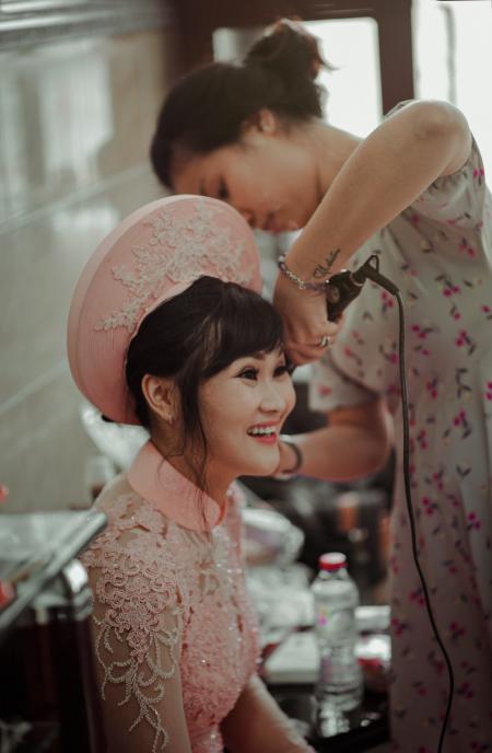 Woman in Pink Collared Blouse Smiling While Sitting