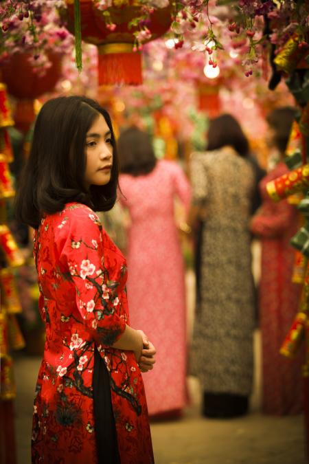 Woman in Red and White Floral Slit Dress Standing in Red Floral Arch