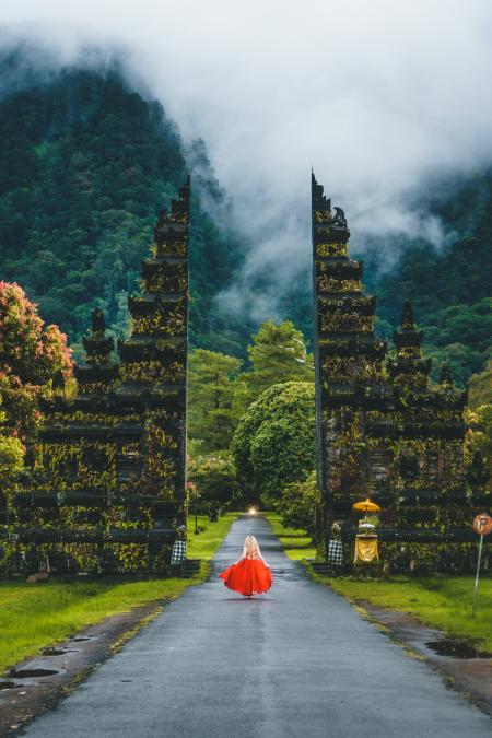 Woman in Red Dress Standing on Gray Road