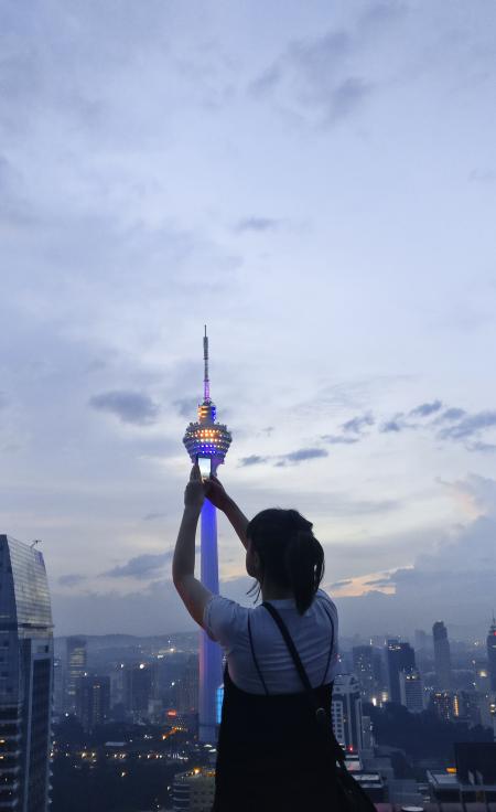 Woman in White and Black Shirt Standing Beside White Tower